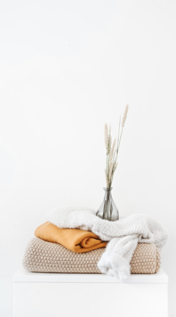 Stack of clean spa towels with a small bouquet of flowers