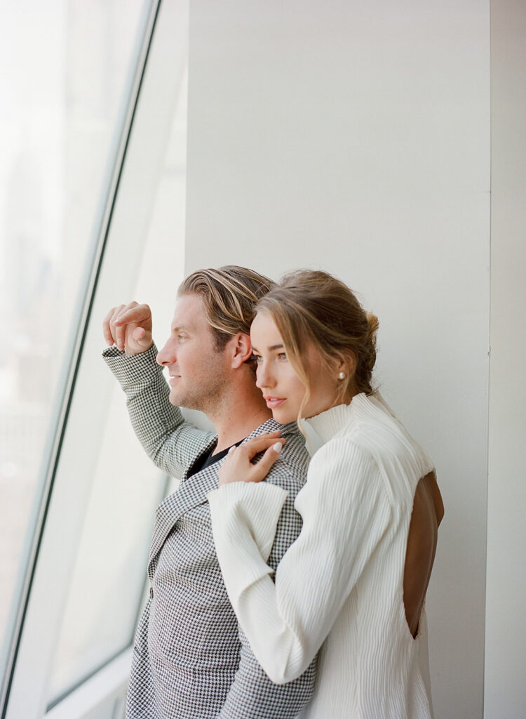 Couple gazing out of window during New York engagement session