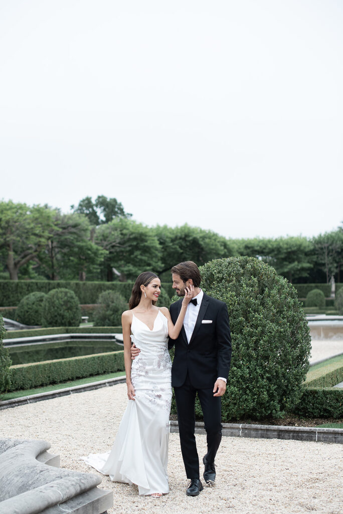 Bride and groom walking through landscaped garden in New York